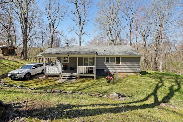 back of property with a chimney, a yard, and a wooden deck