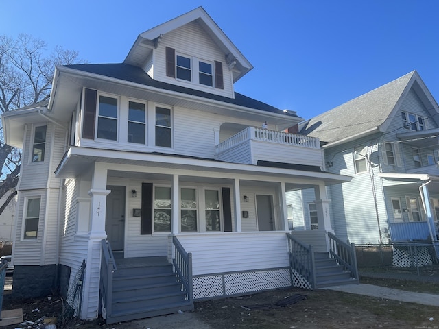 american foursquare style home with a balcony and covered porch