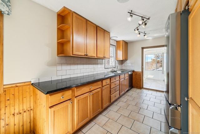 kitchen with a sink, dishwashing machine, wainscoting, freestanding refrigerator, and open shelves