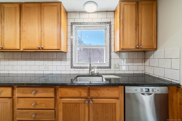 kitchen with a sink, dark stone countertops, tasteful backsplash, stainless steel dishwasher, and brown cabinetry