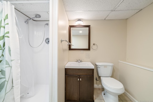 bathroom with tile patterned floors, a drop ceiling, curtained shower, and vanity