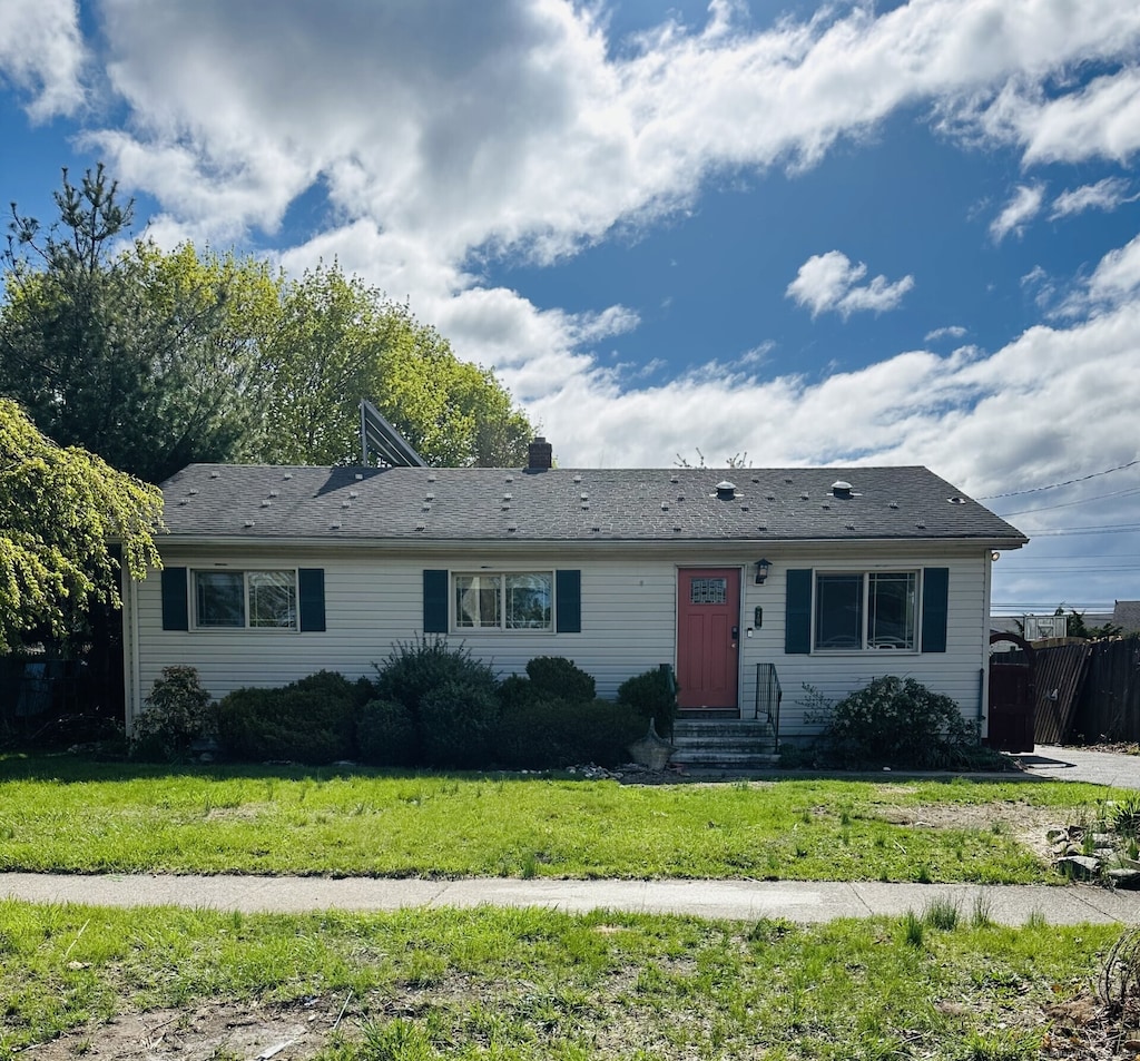 single story home with entry steps and a front lawn