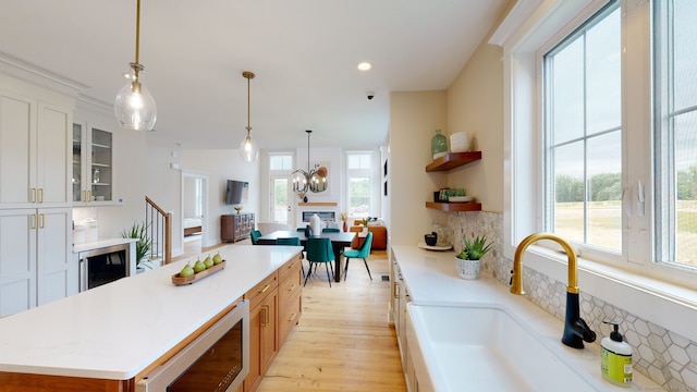 kitchen featuring a kitchen island, light countertops, a sink, and open shelves