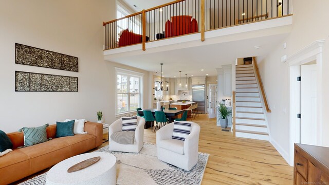 81 Shea Cir, Cheshire, CT 06410 - living area featuring baseboards, stairs, a towering ceiling, and light wood finished floors