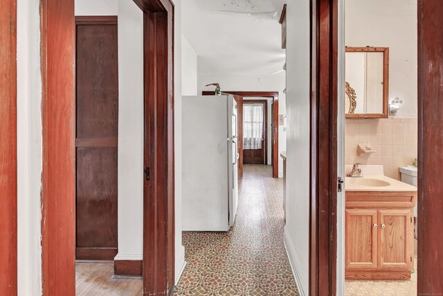 hallway with a sink and baseboards