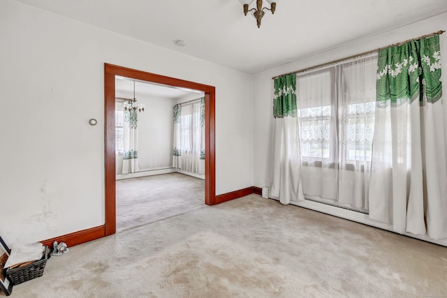empty room with baseboards, carpet flooring, and a notable chandelier