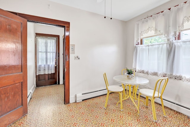 dining room featuring baseboards, light floors, and a baseboard radiator