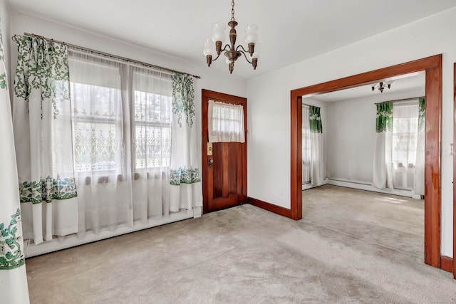 carpeted entryway featuring baseboards, a baseboard radiator, baseboard heating, and a notable chandelier