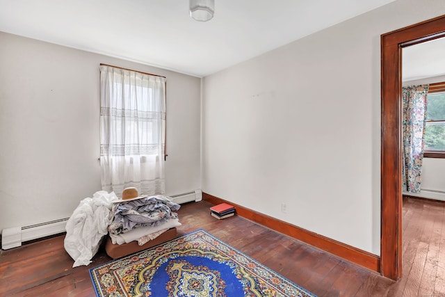 bedroom featuring baseboards, baseboard heating, and hardwood / wood-style floors