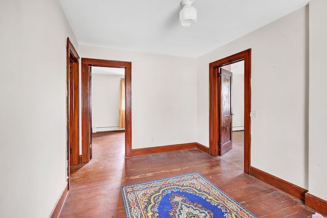 hall with baseboards, baseboard heating, and hardwood / wood-style flooring