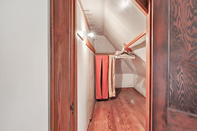 walk in closet featuring vaulted ceiling and wood finished floors