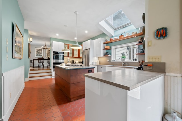 277 Milton Rd, Warren, CT 06756 - kitchen with a sink, open shelves, stainless steel appliances, white cabinetry, and a center island