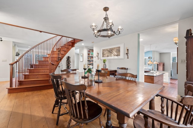277 Milton Rd, Warren, CT 06756 - dining room featuring light wood-type flooring, stairs, a chandelier, and baseboards