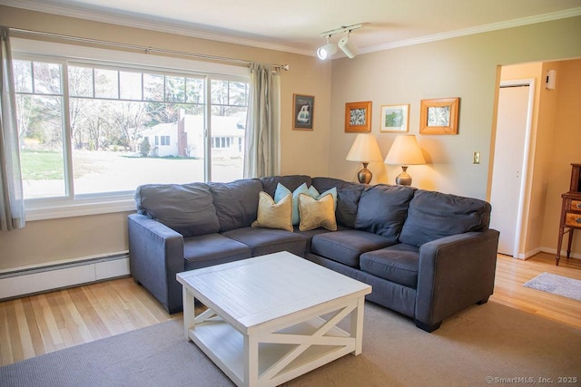 living area featuring plenty of natural light, ornamental molding, a baseboard heating unit, and light wood-type flooring