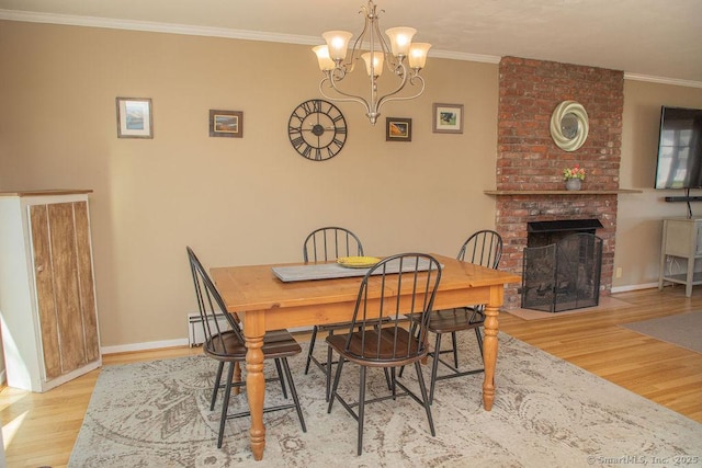 dining area featuring baseboards, a chandelier, wood finished floors, and a fireplace
