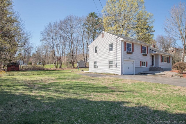 view of home's exterior featuring a garage, a yard, and aphalt driveway