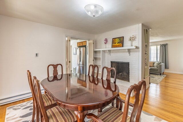 127 Separatist Rd, Mansfield, CT 06268 - dining area with light wood-style flooring, a fireplace, baseboard heating, and baseboards