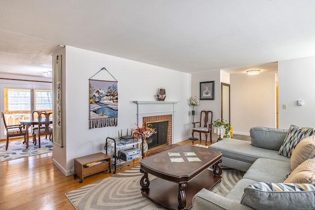 127 Separatist Rd, Mansfield, CT 06268 - living room featuring light wood-style flooring, a brick fireplace, and baseboards