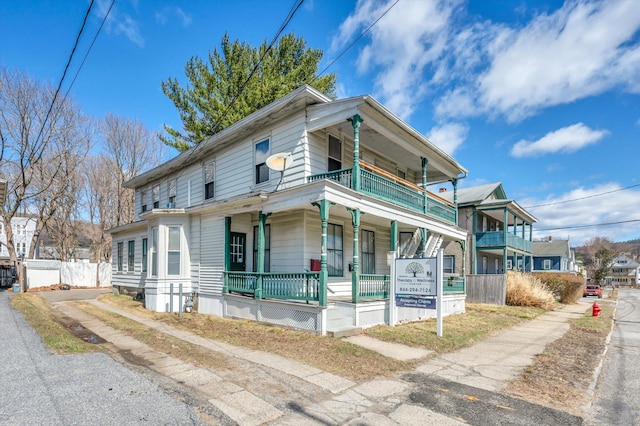view of front of house with a balcony, fence, and covered porch