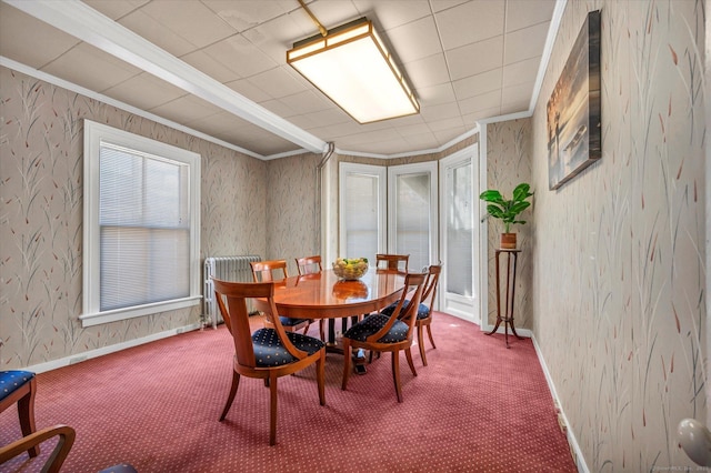 dining space featuring wallpapered walls, crown molding, baseboards, and carpet floors