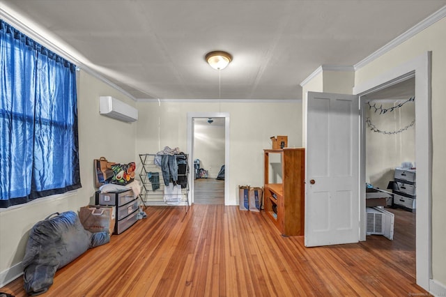 interior space with an AC wall unit, wood finished floors, and crown molding