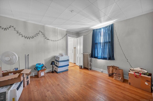 misc room featuring ornamental molding, radiator, baseboards, and wood finished floors