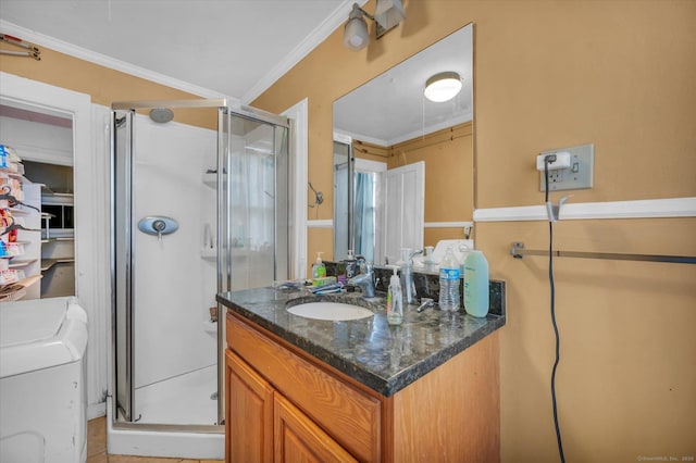 bathroom with vanity, washer / dryer, a shower stall, and ornamental molding