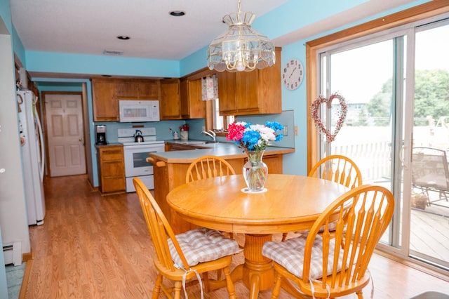 33 Oxford Dr, South Windsor, CT 06074 - dining space featuring light wood-style flooring, a baseboard radiator, and a chandelier