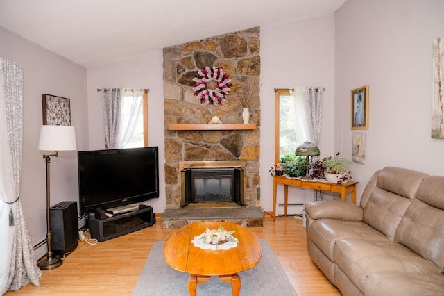 33 Oxford Dr, South Windsor, CT 06074 - living room featuring lofted ceiling, a baseboard heating unit, wood finished floors, and a stone fireplace
