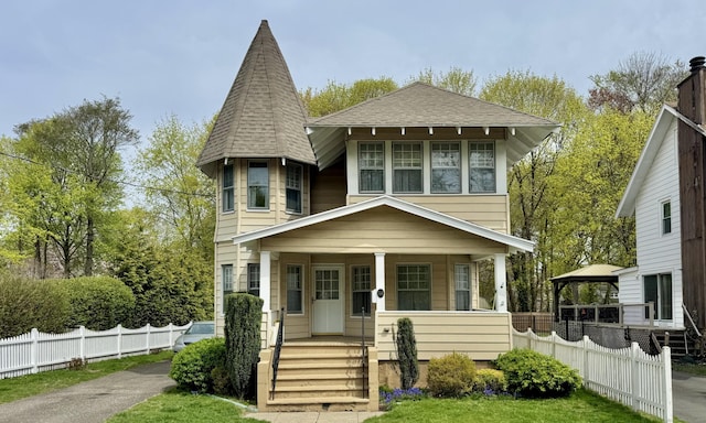 view of front of home with a gazebo, fence, covered porch, and a shingled roof