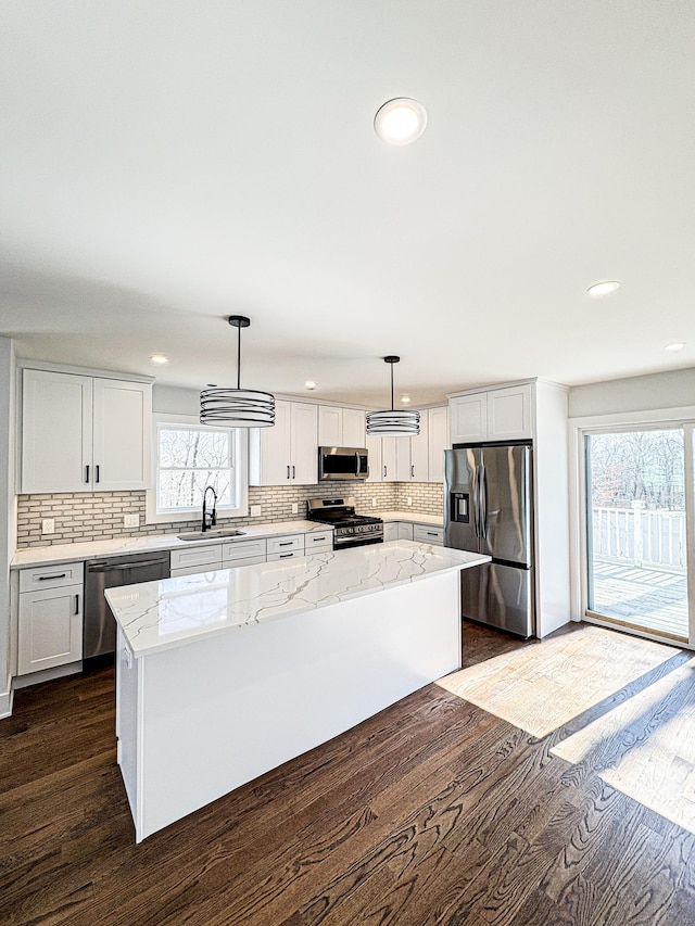 88 Walnut Trl, Danbury, CT 06810 - kitchen with stainless steel appliances, dark wood-type flooring, decorative backsplash, a sink, and a kitchen island