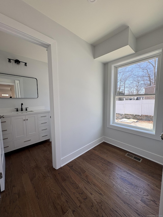 88 Walnut Trl, Danbury, CT 06810 - unfurnished bedroom with a sink, dark wood-style floors, and baseboards