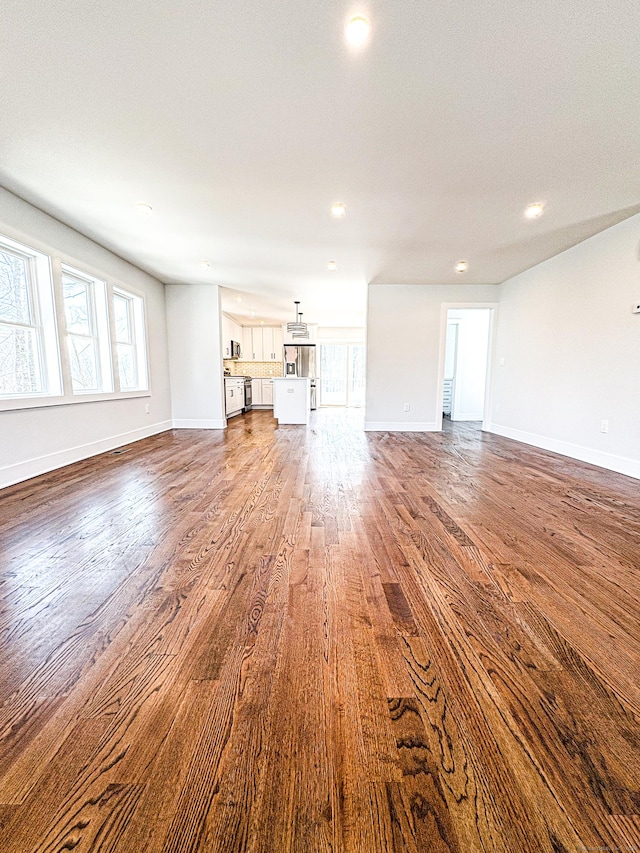 88 Walnut Trl, Danbury, CT 06810 - unfurnished living room featuring dark wood finished floors, baseboards, plenty of natural light, and recessed lighting