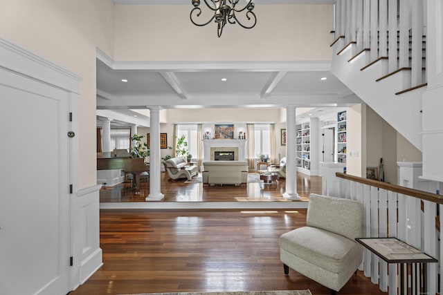 360 New London Tpke, Stonington, CT 06378 - entryway with decorative columns, beam ceiling, a glass covered fireplace, wood finished floors, and a chandelier