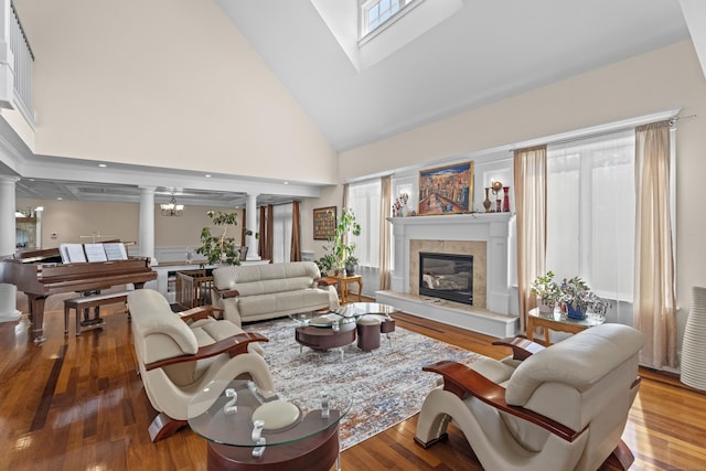360 New London Tpke, Stonington, CT 06378 - living area featuring high vaulted ceiling, ornate columns, a tile fireplace, and wood finished floors