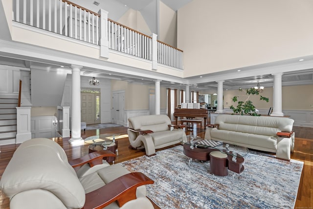 360 New London Tpke, Stonington, CT 06378 - living room featuring ornate columns, wood finished floors, a decorative wall, wainscoting, and stairway
