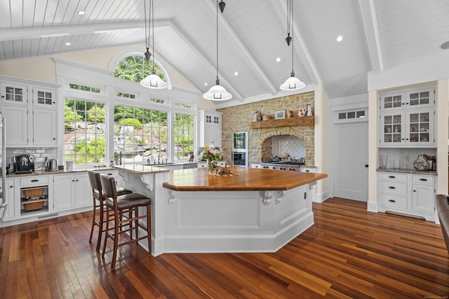 360 New London Tpke, Stonington, CT 06378 - kitchen featuring wooden counters, dark wood finished floors, a stone fireplace, a spacious island, and white cabinetry