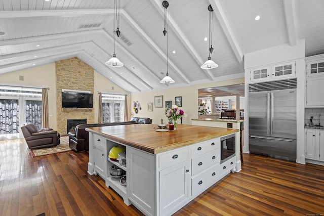 360 New London Tpke, Stonington, CT 06378 - kitchen featuring built in appliances, dark wood finished floors, open floor plan, white cabinets, and a fireplace