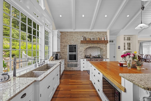 360 New London Tpke, Stonington, CT 06378 - kitchen with a warming drawer, stainless steel appliances, dark wood-style floors, white cabinetry, and a fireplace