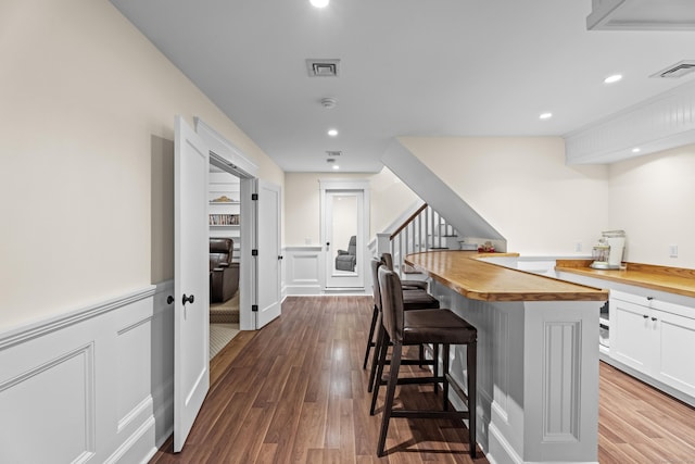 360 New London Tpke, Stonington, CT 06378 - kitchen with wooden counters, a breakfast bar area, white cabinets, dark wood-style floors, and recessed lighting