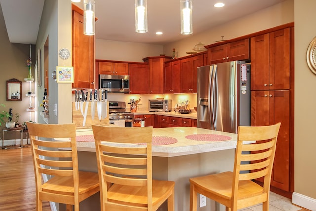 36 Barbers Way Unit 36, Hebron, CT 06248 - kitchen featuring a kitchen breakfast bar, stainless steel appliances, light countertops, a toaster, and hanging light fixtures
