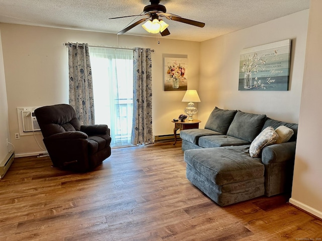 living area with a textured ceiling, ceiling fan, wood finished floors, and baseboard heating