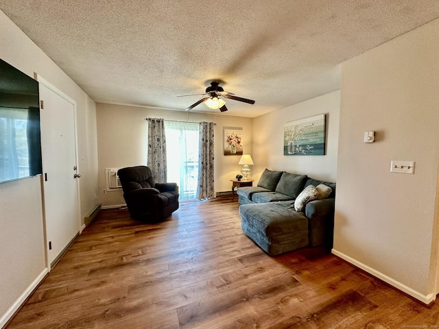 living room featuring wood finished floors, baseboards, a textured ceiling, ceiling fan, and baseboard heating