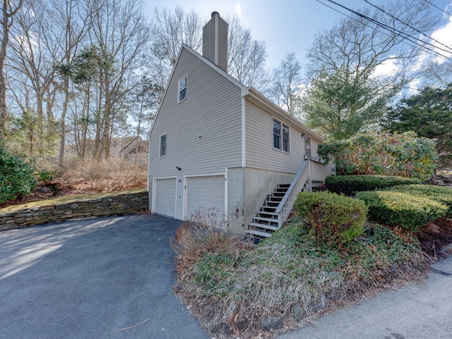20 Copper Hill Dr Unit 20, Guilford, CT 06437 - view of side of home featuring stairs, driveway, a garage, and a chimney