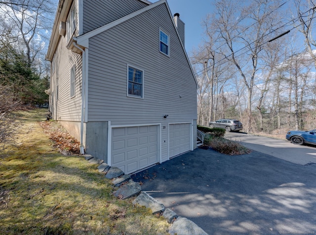 20 Copper Hill Dr Unit 20, Guilford, CT 06437 - view of side of home with a garage, aphalt driveway, and a chimney