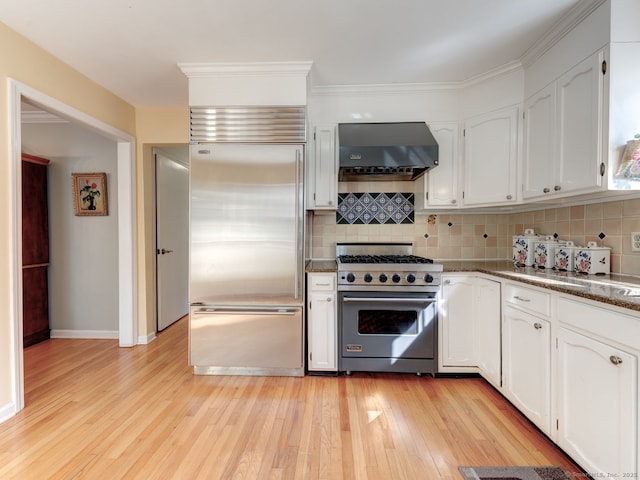 20 Copper Hill Dr Unit 20, Guilford, CT 06437 - kitchen with decorative backsplash, light wood-style flooring, high end appliances, white cabinetry, and ventilation hood