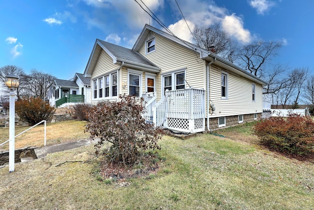 view of side of home with a wooden deck and a lawn