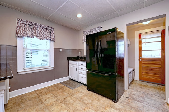 kitchen featuring dark countertops, a paneled ceiling, white cabinetry, and freestanding refrigerator
