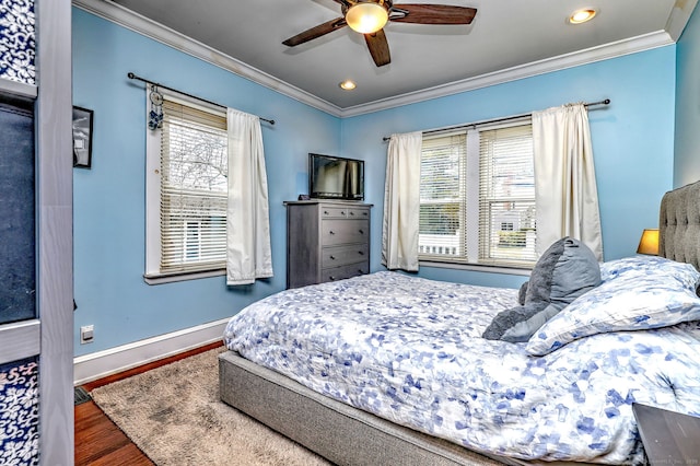 bedroom featuring ornamental molding, multiple windows, and wood finished floors
