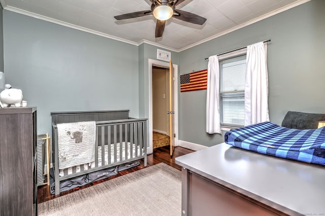 bedroom with baseboards, ornamental molding, wood finished floors, and a ceiling fan